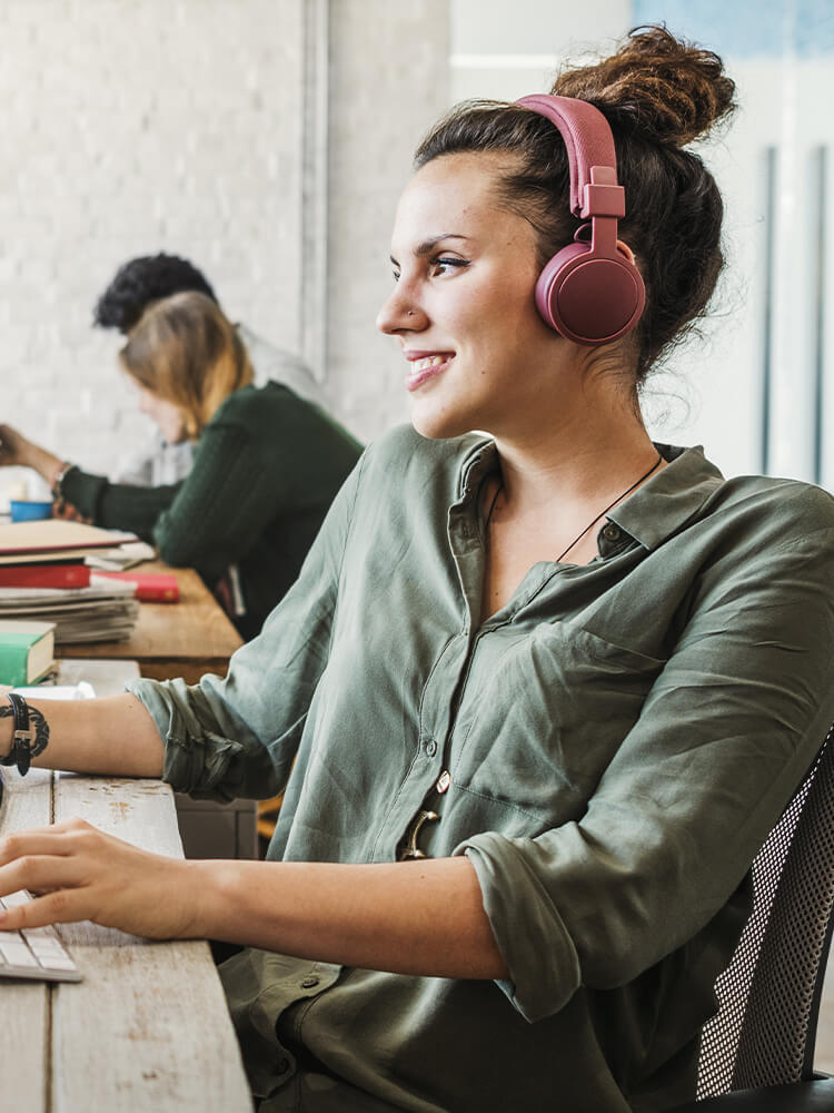 Woman in an office wearing headphones and smiling
