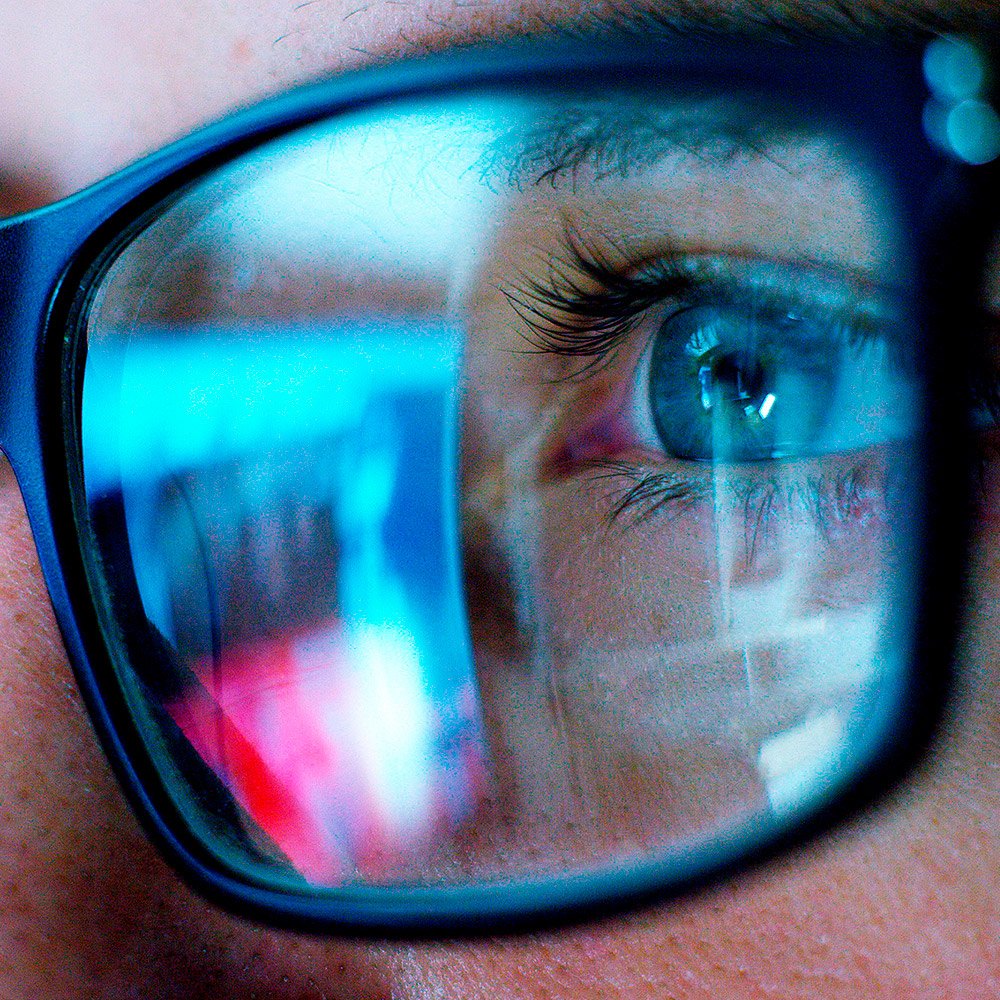 Reflection of the screen content on the glasses of a businesswoman