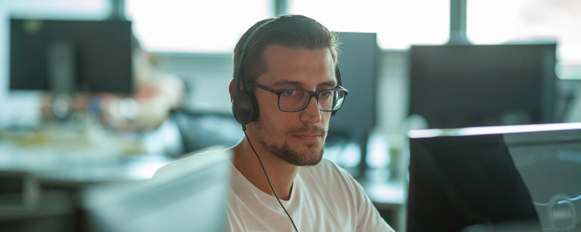 A man with headphones working on the computer